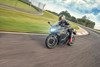 Three-quarter front angle of person riding a motorcycle on a racetrack.