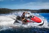 Profile angle of person riding a personal watercraft around a turn on water.