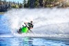 Front angle of person riding a personal watercraft around a turn on water.