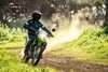 Front angle of person riding a motorcycle on a dirt trail.