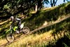 Profile angle of person riding a motorcycle down a dirt trail.