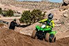 Three-quarter front angle of person riding an ATV on a dirt track.