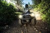 Front angle of person riding an ATV over a dirt trail.