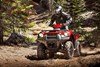 Three-quarter front angle of person riding an ATV on a dirt trail.