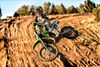 Profile angle of person whipping a motorcycle on a dirt track.