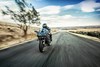 Front angle of person riding a motorcycle on a paved road.
