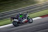 Profile angle of person riding a motorcycle on a racetrack. 