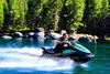 Profile angle of person riding a personal watercraft over water.